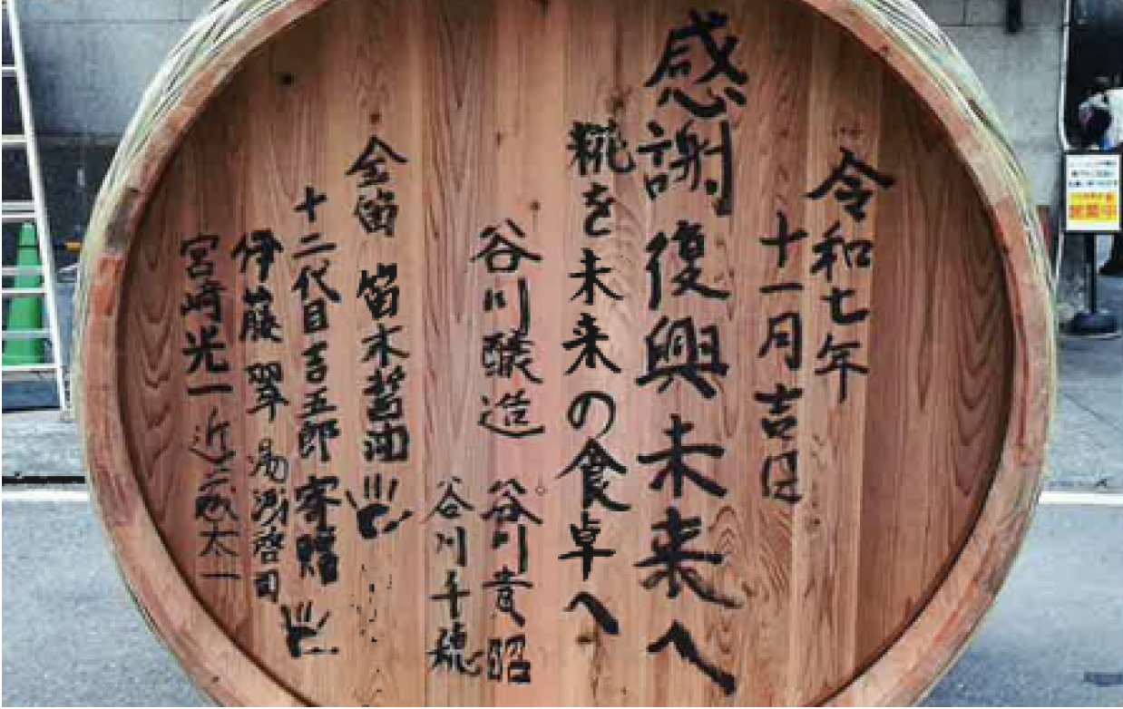 寄贈される木桶の底板に書かれた寄せ書き