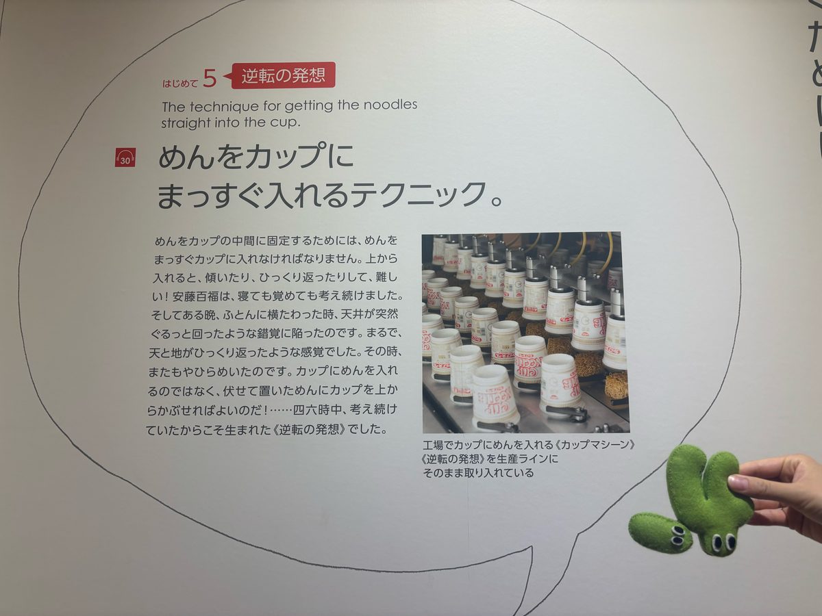 「めんをカップにまっすぐ入れるテクニック。」と題した「逆転の発想」の解説パネルと、かてぽん